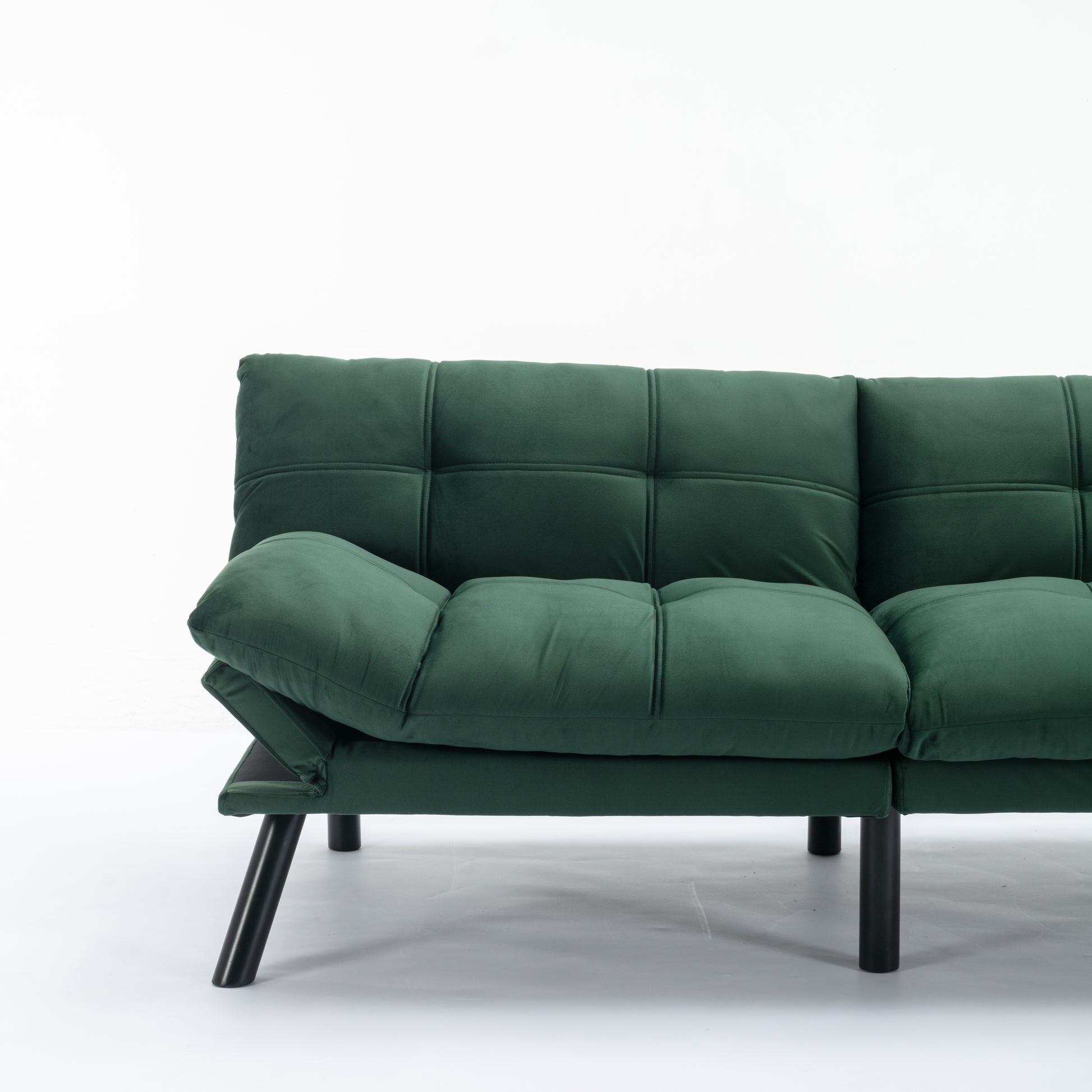 Dark green velvet sofa with tufted cushions and black metal legs