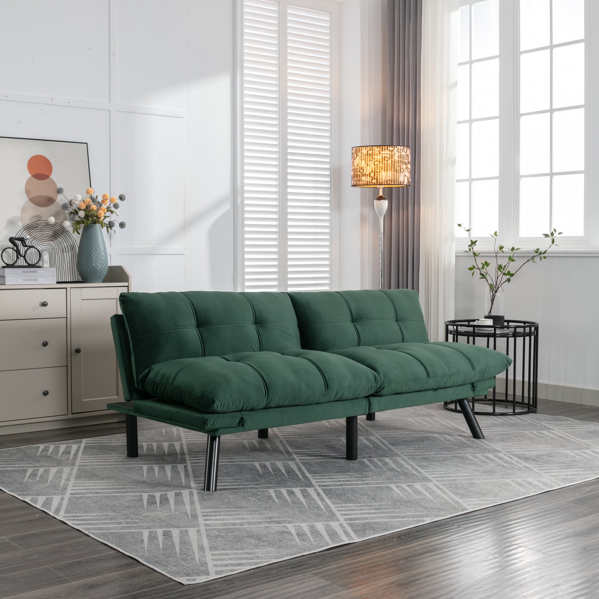 Deep green velvet futon sofa with tufted cushions on modern chrome legs