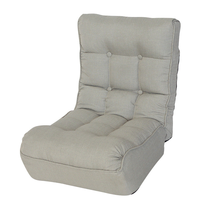 Padded grey floor chair with tufted backrest and seat for gaming