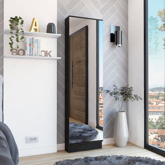 Tall black framed full length mirror reflecting a wooden door