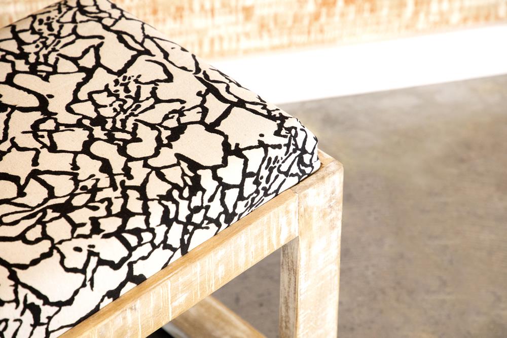 Wooden stool with a black and white abstract pattern cushion