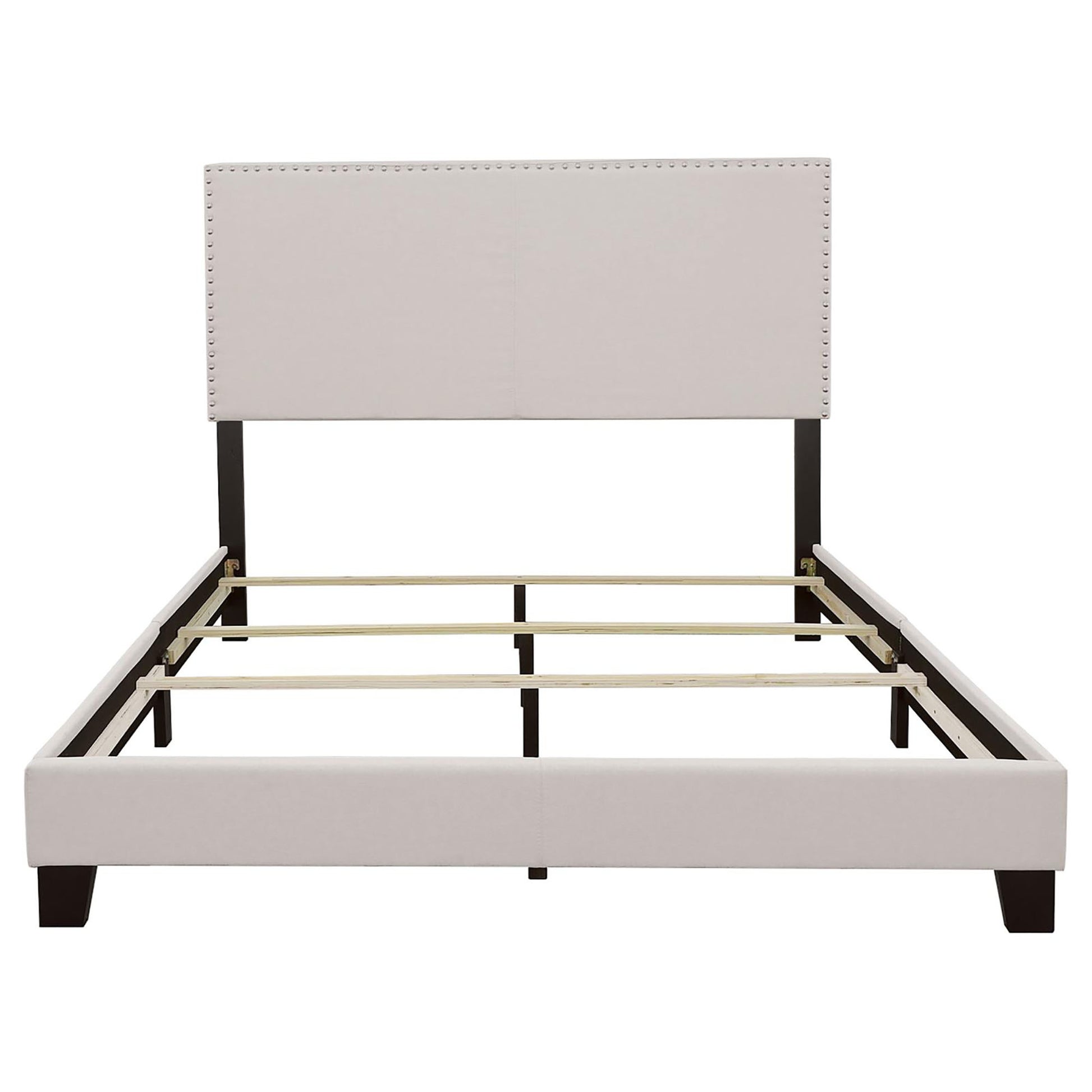 Upholstered bed frame with nailhead trim headboard and dark wood legs