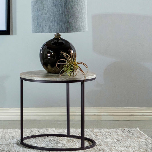 Round marble top side table with dark metal frame and decorative lamp