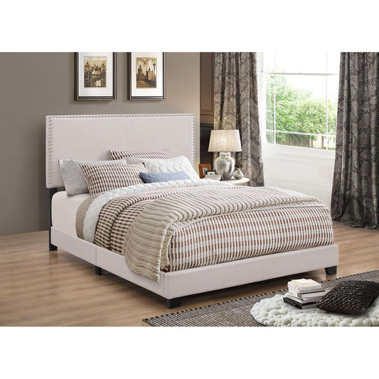 Upholstered queen bed frame in cream fabric with studded headboard