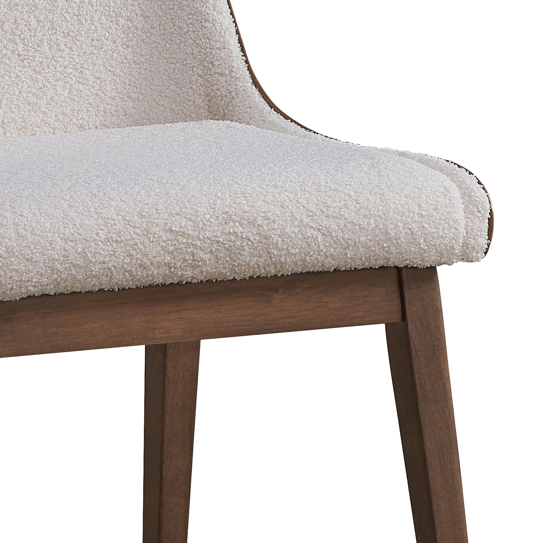 Closeup of plush cream boucle fabric chair seat with dark wood legs