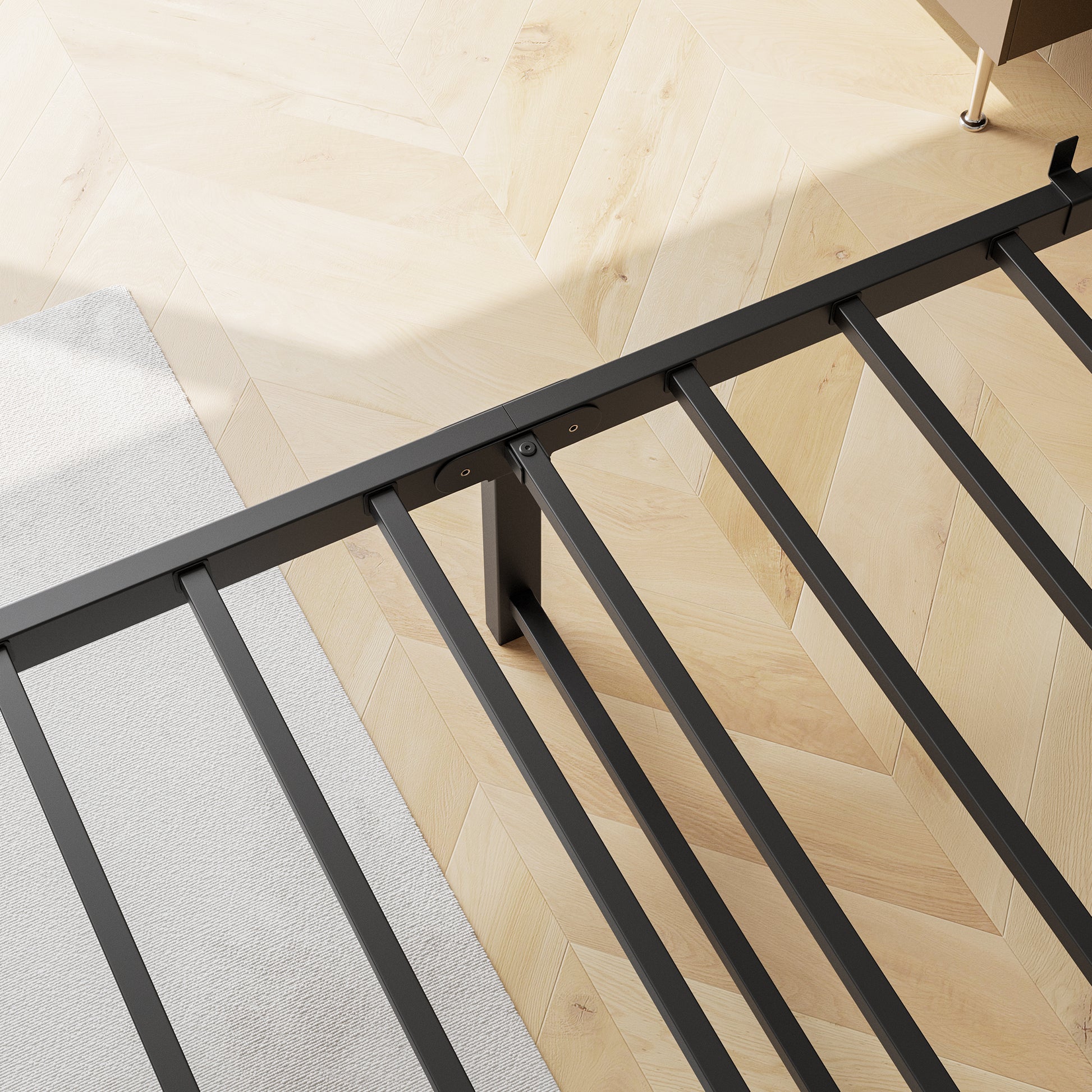 Black metal bed frame slats on blonde wood floor with white rug