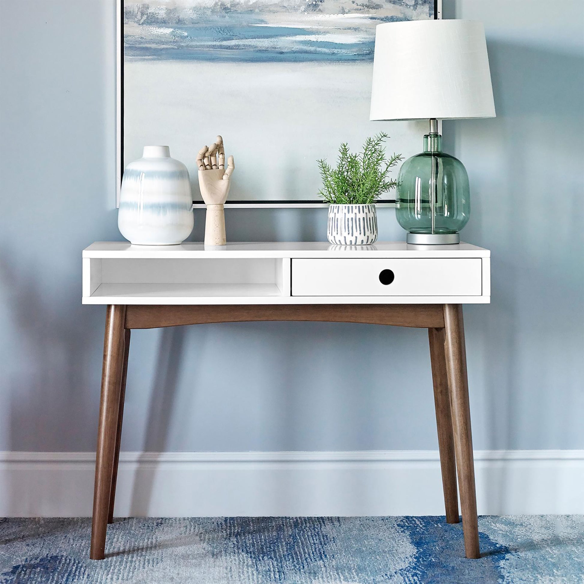 White console table with tapered wooden legs and one drawer