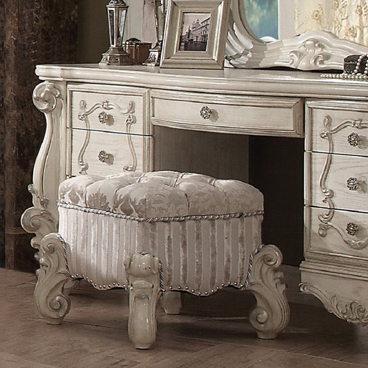 Tufted upholstered vanity stool in cream with silver trim and ornate legs