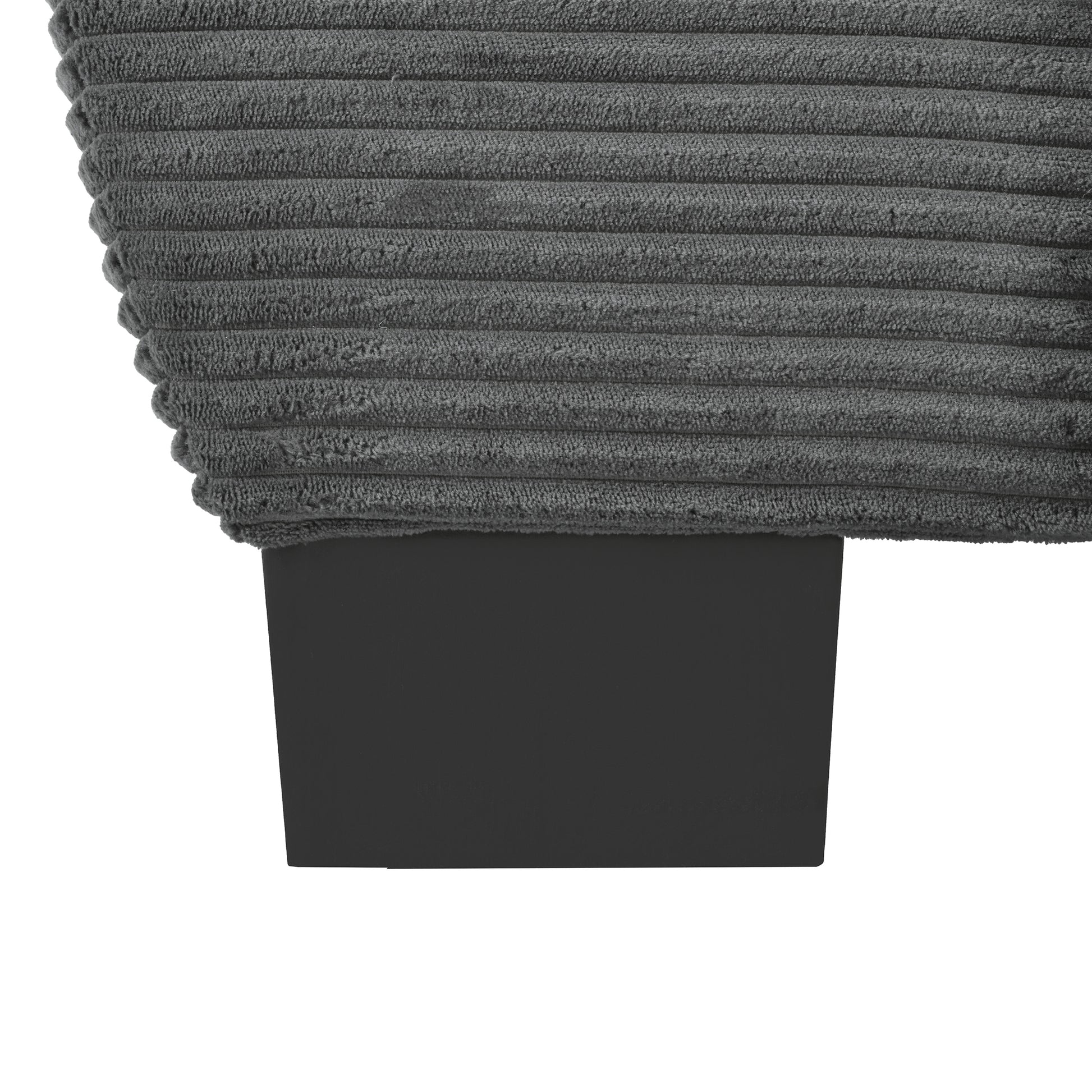 Closeup of a grey corduroy fabric texture on a sofa cushion with a black wooden leg