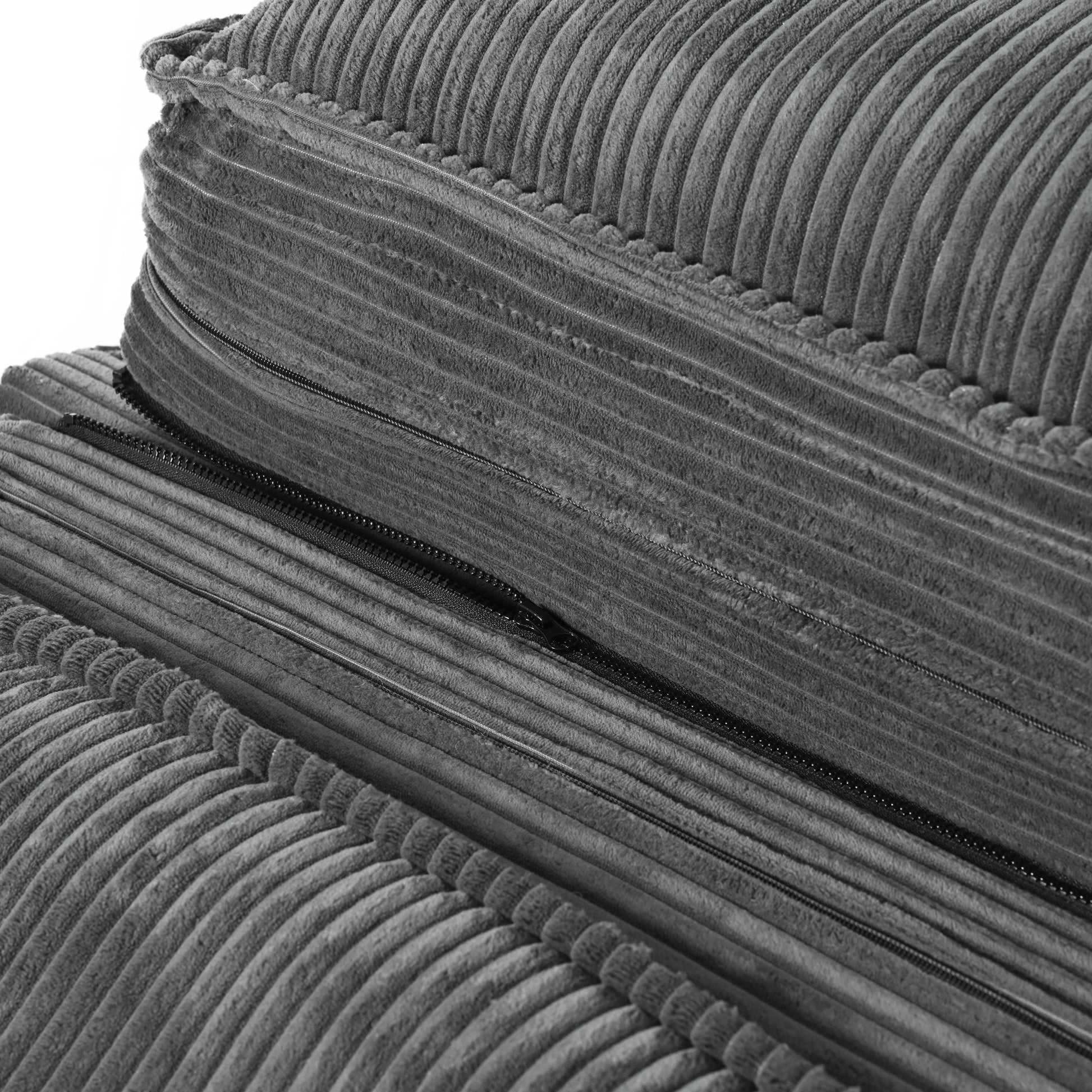 Closeup of dark grey corduroy fabric cushion with exposed black zipper detail