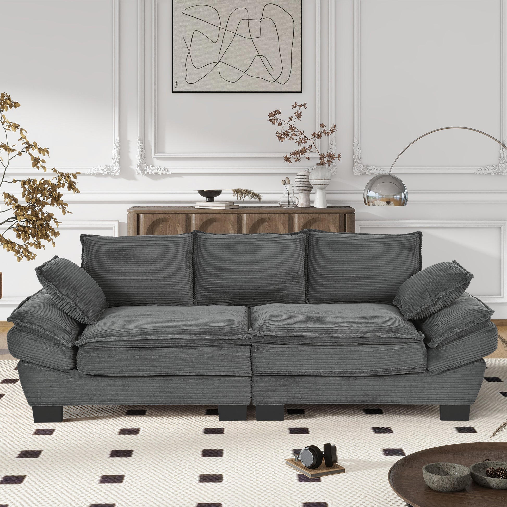 Plush grey corduroy threeseater sofa with deep seat cushions and oversized throw pillows