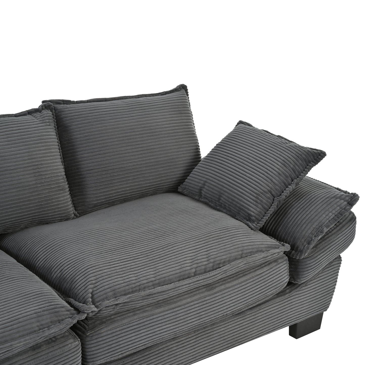Closeup of a plush dark grey corduroy sofa with deep cushions and accent pillows
