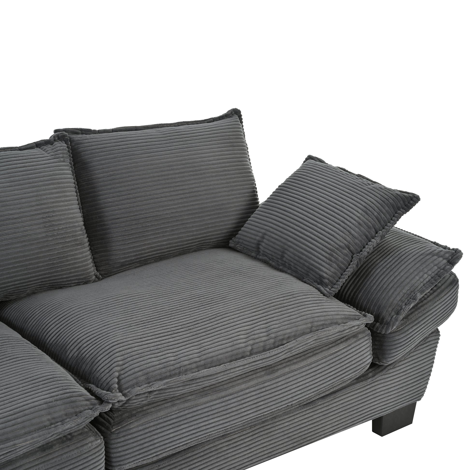 Closeup of a plush dark grey corduroy sofa with deep cushions and accent pillows