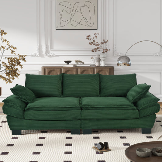 Emerald green corduroy sofa with plush cushions and tufted details