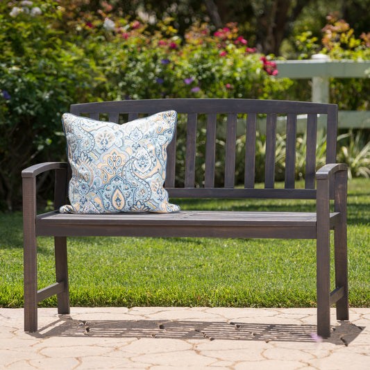 Dark brown wooden garden bench with a decorative outdoor cushion