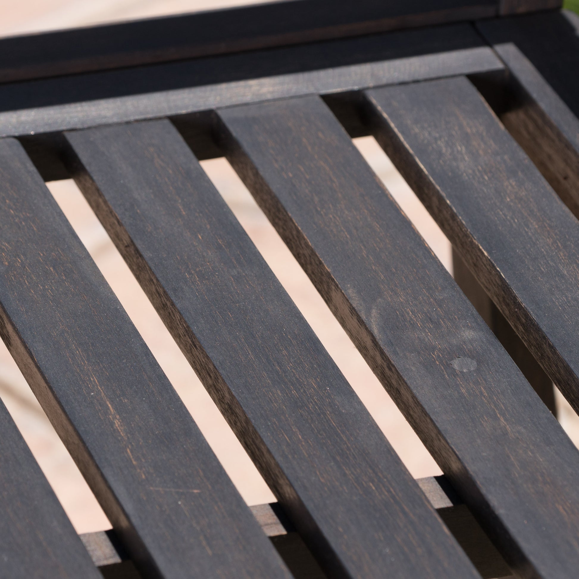 Dark brown slatted wooden lounger detail perfect for patio relaxation