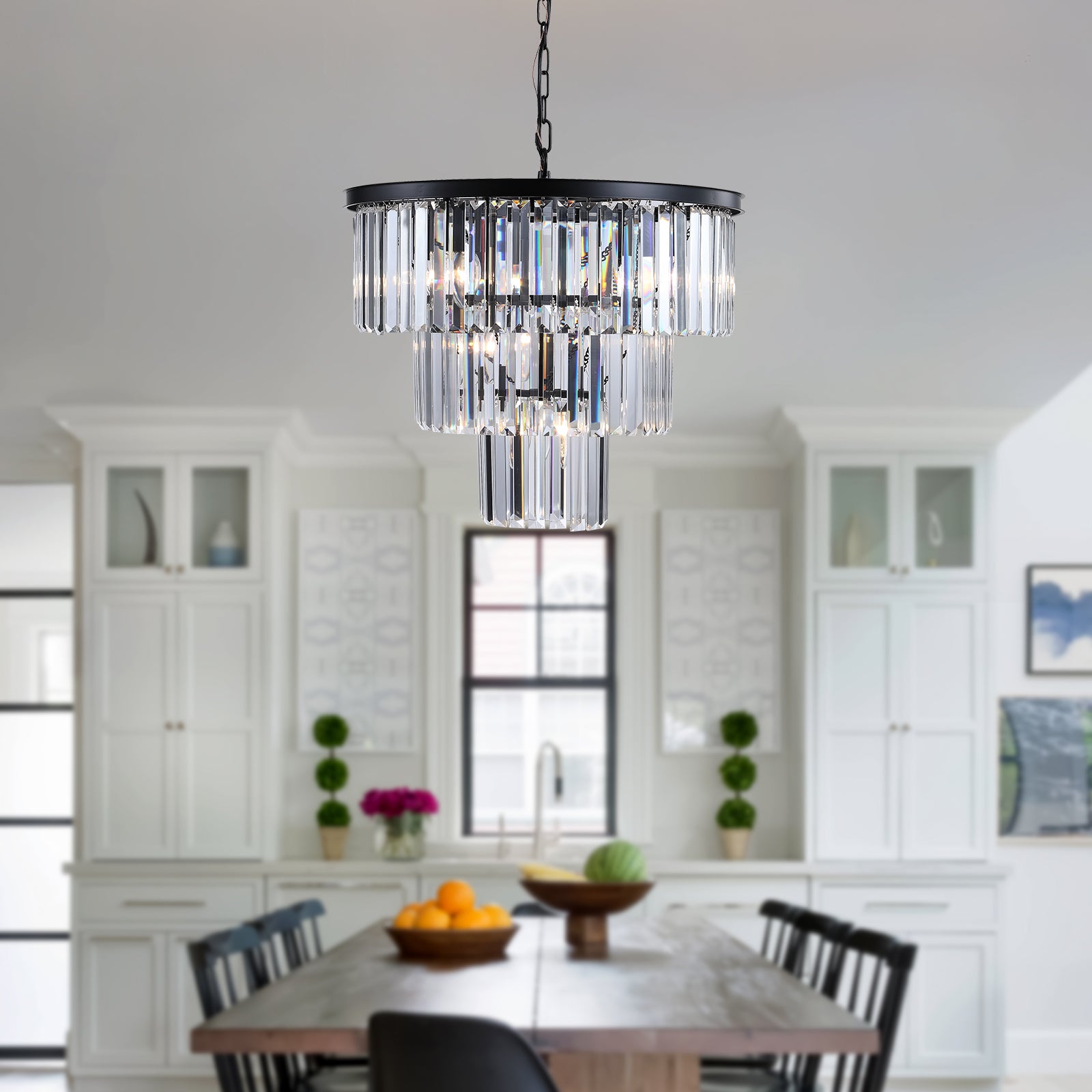 Threetier crystal chandelier with black metal frame casting warm light