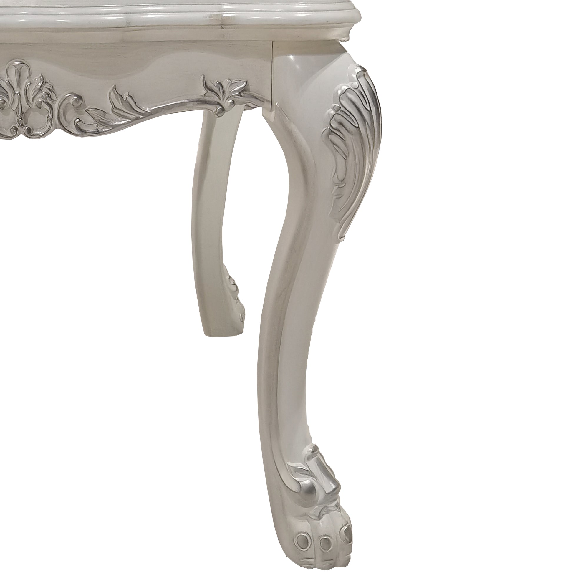Ornate white carved table leg with silver accents