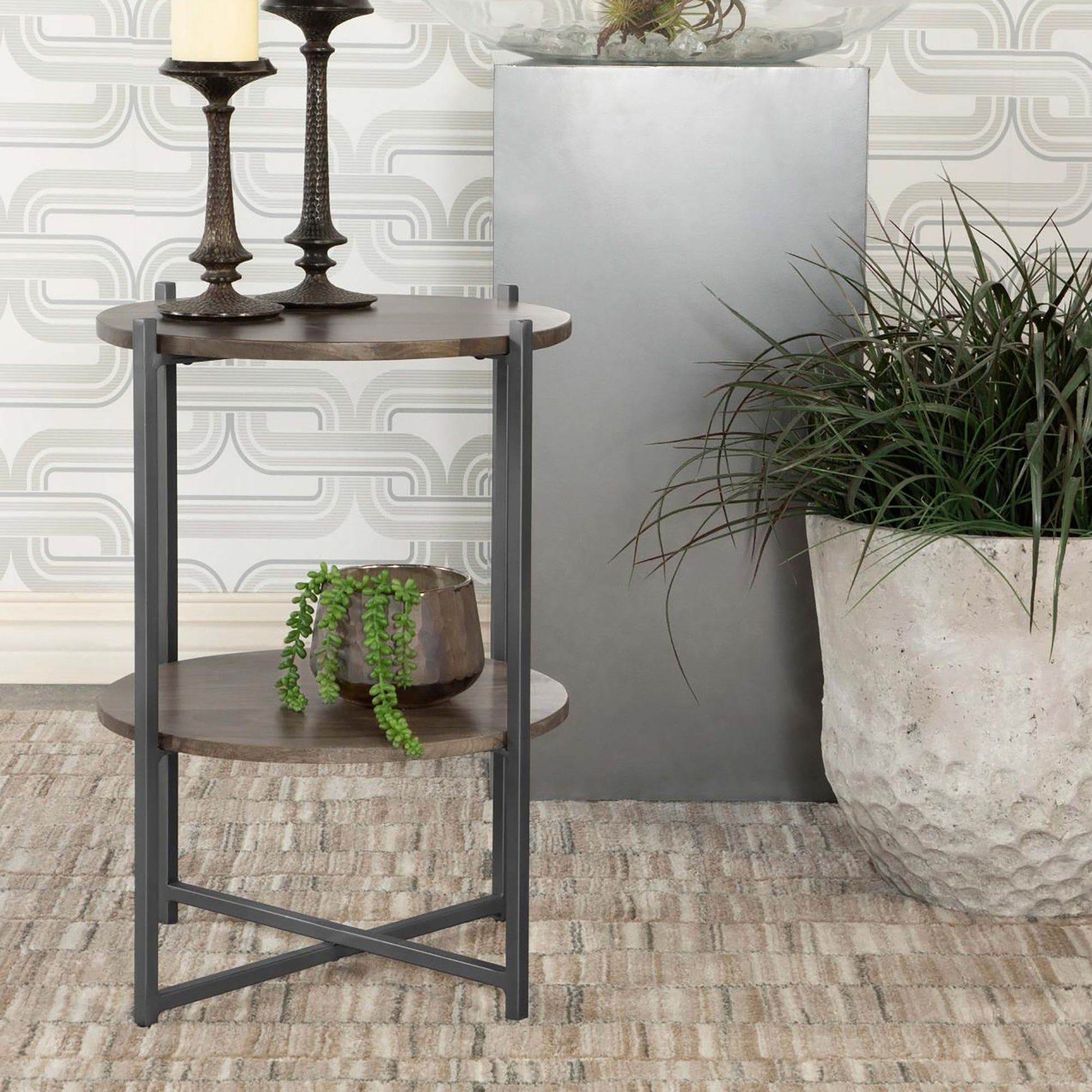 Round wood end table with dark metal frame and two shelves showcasing a modern farmhouse style