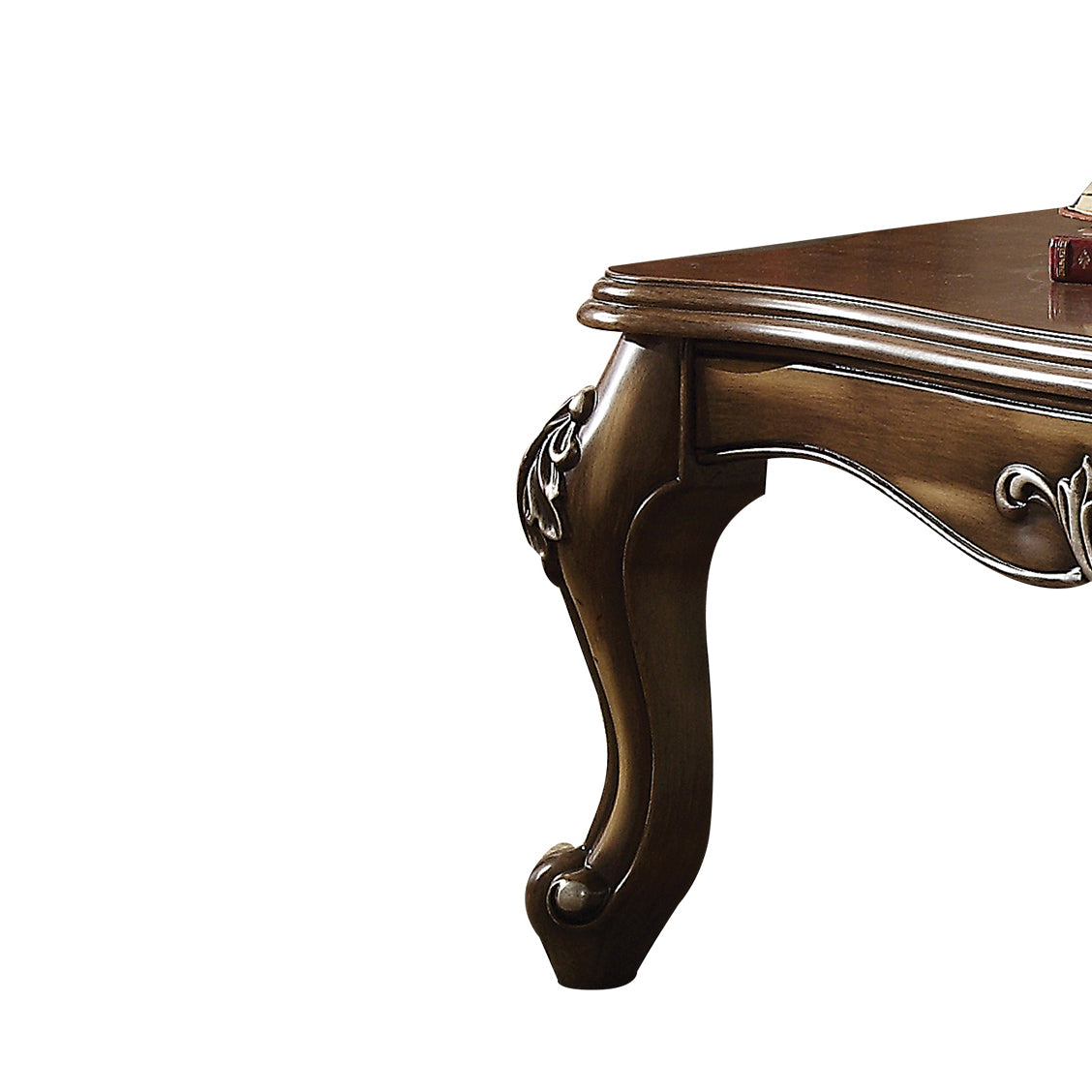 Ornate carved wood leg of a dark brown vintage coffee table