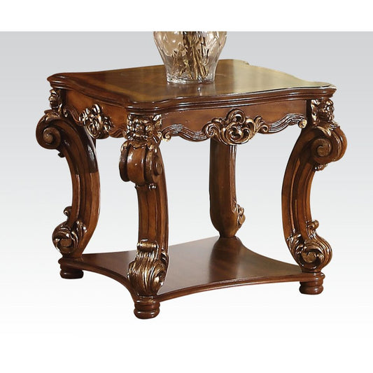 Ornate wood accent table with carved legs and metallic gold accents