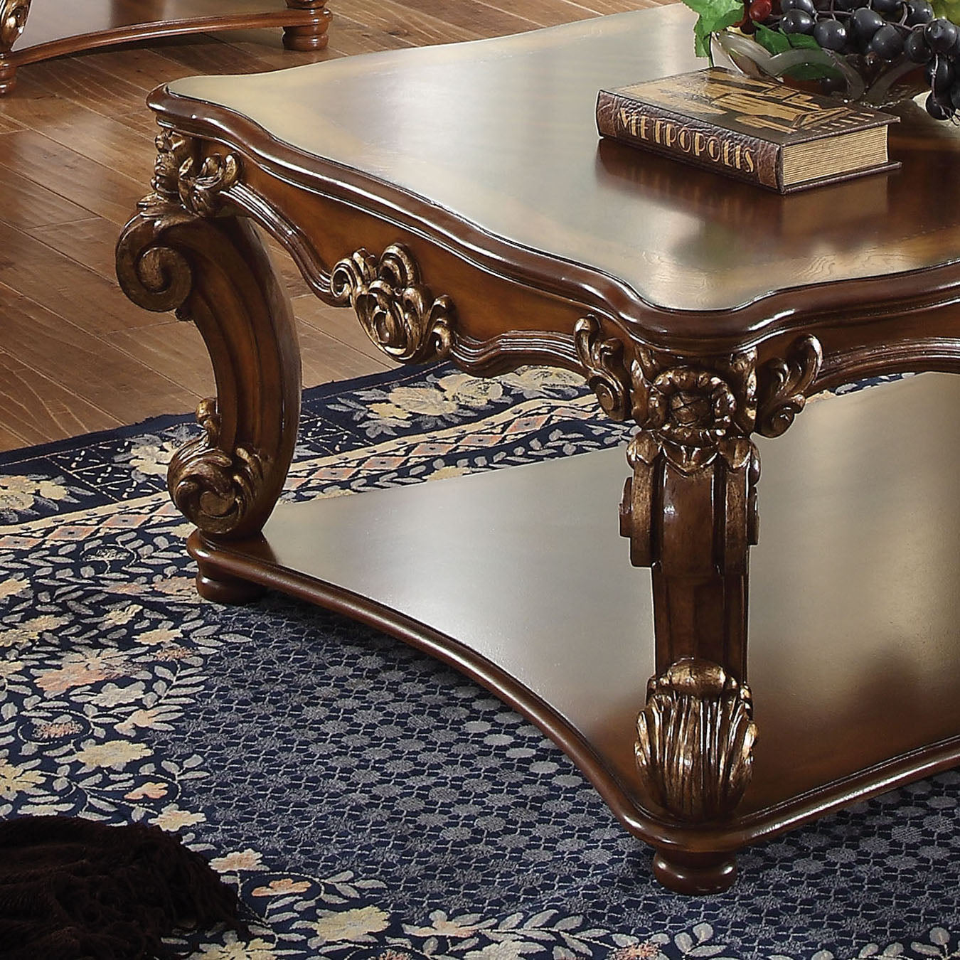 Ornate wooden coffee table with scrolled legs and gold accents