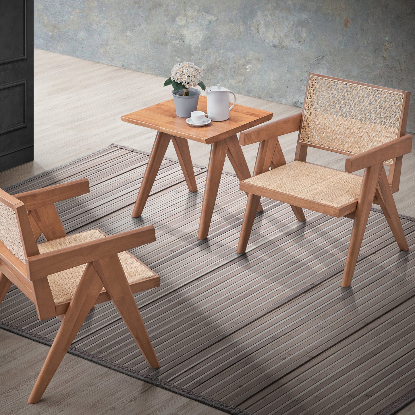Two modern rattan accent chairs and a small wooden side table with a coffee set