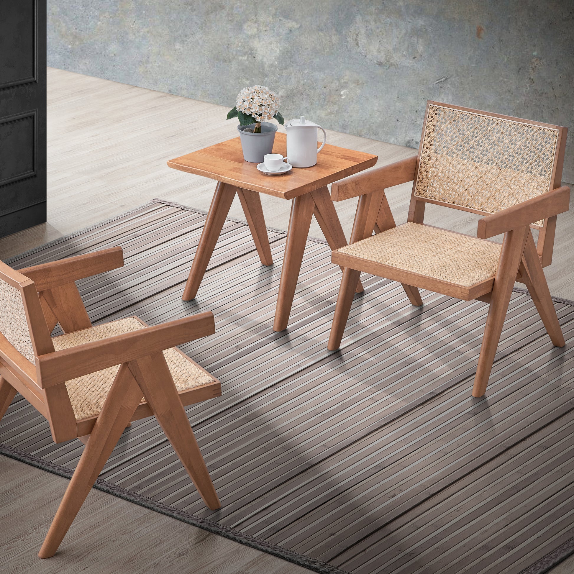Two modern rattan accent chairs and a small wooden side table with a coffee set