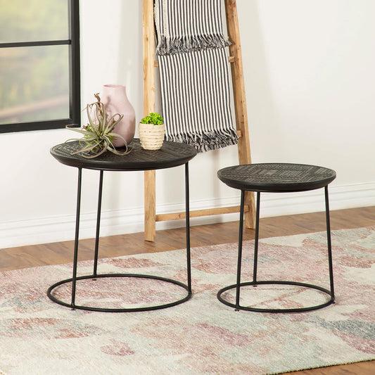 Two round black metal nesting tables with textured tops and slender legs