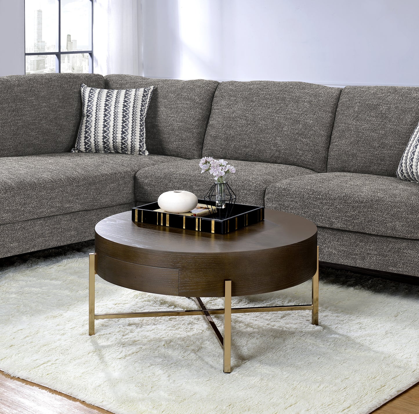 Round wood coffee table with gold metal legs and black tray with gold accents