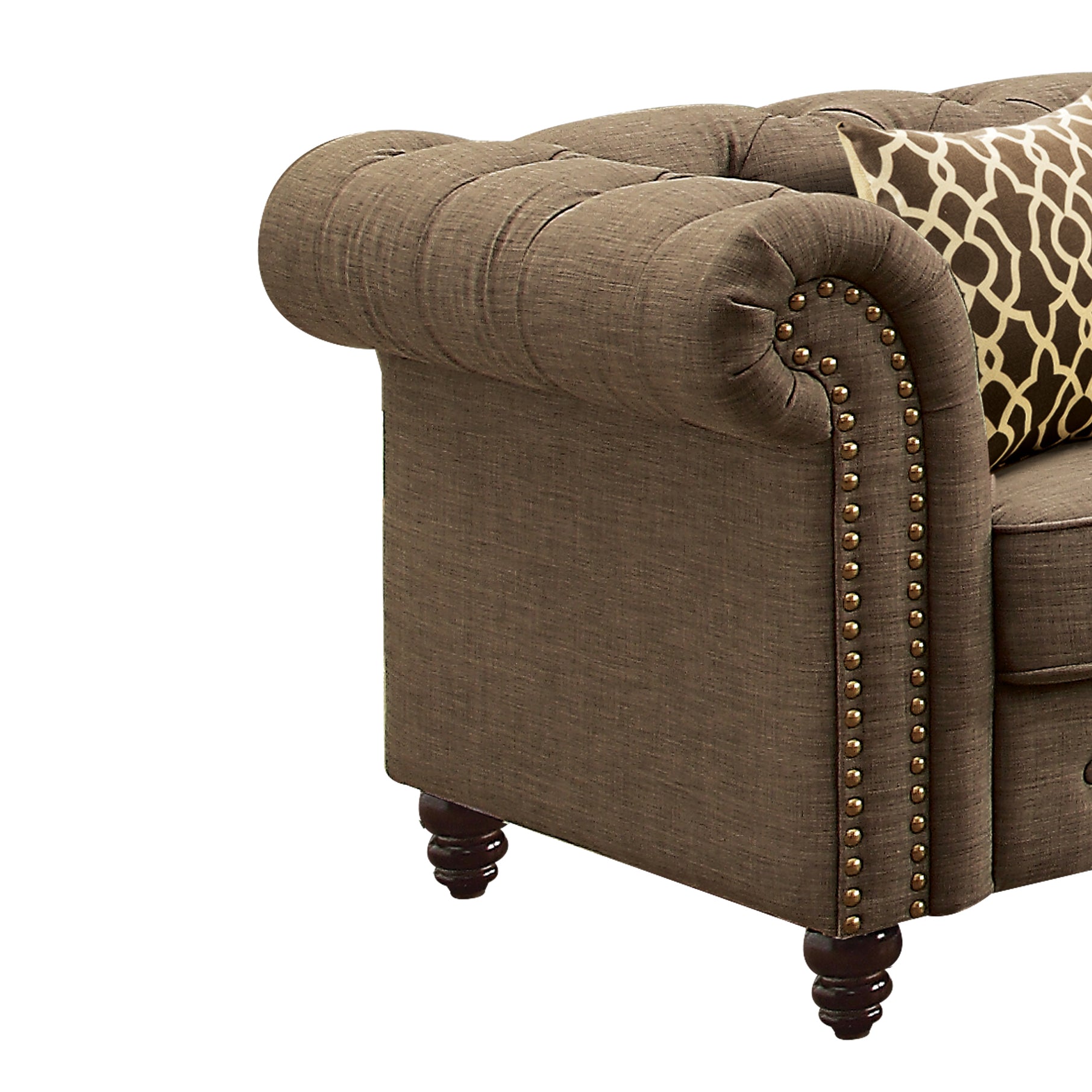 Brown fabric chesterfield armchair arm with decorative nailhead trim and patterned pillow