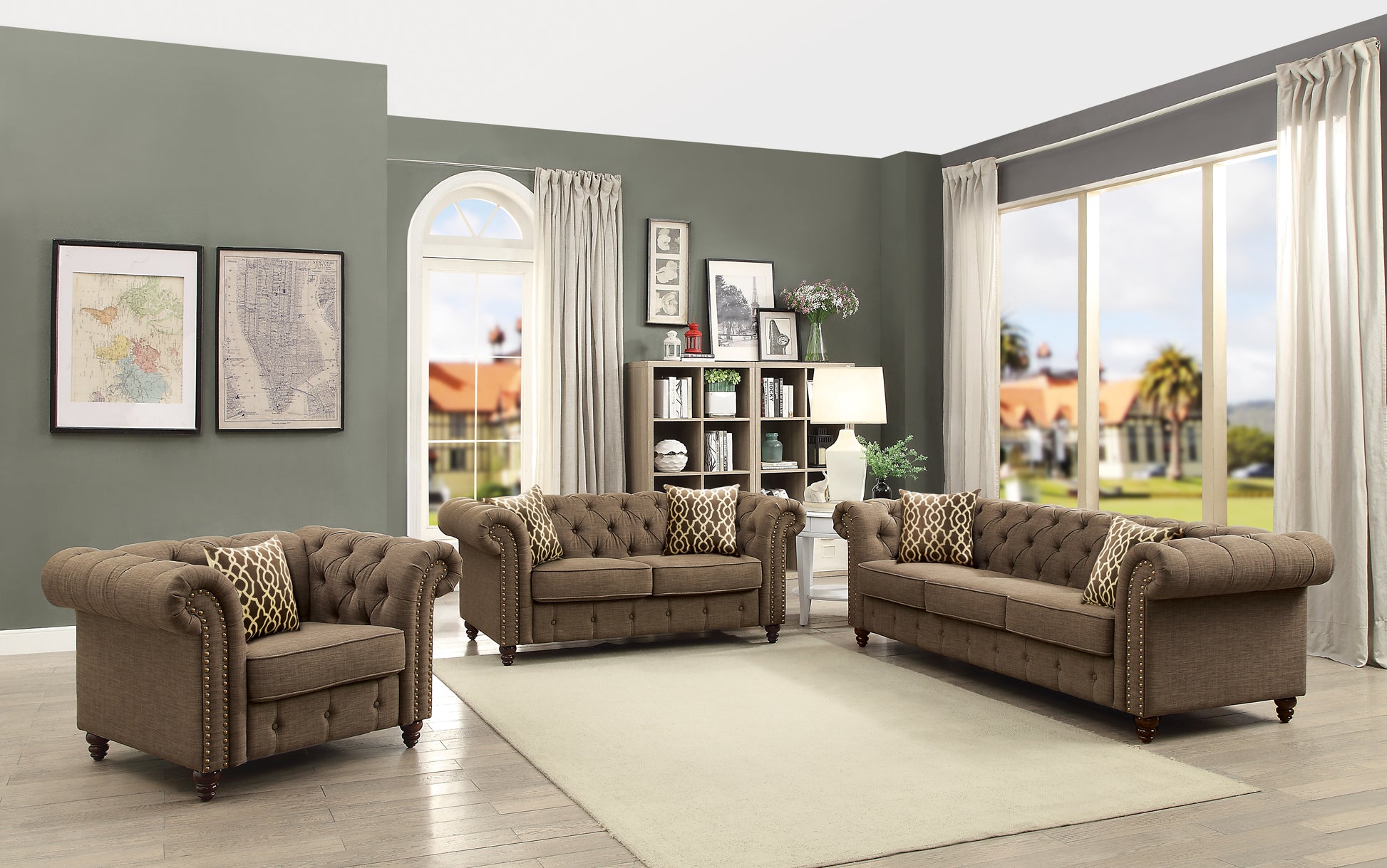 Brown tufted chesterfield sofa with gold nailhead trim and patterned accent pillows