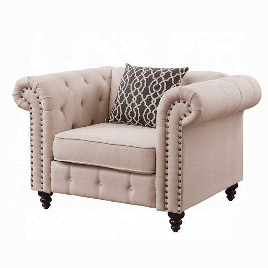Beige linen tufted armchair with nailhead trim and decorative pillow