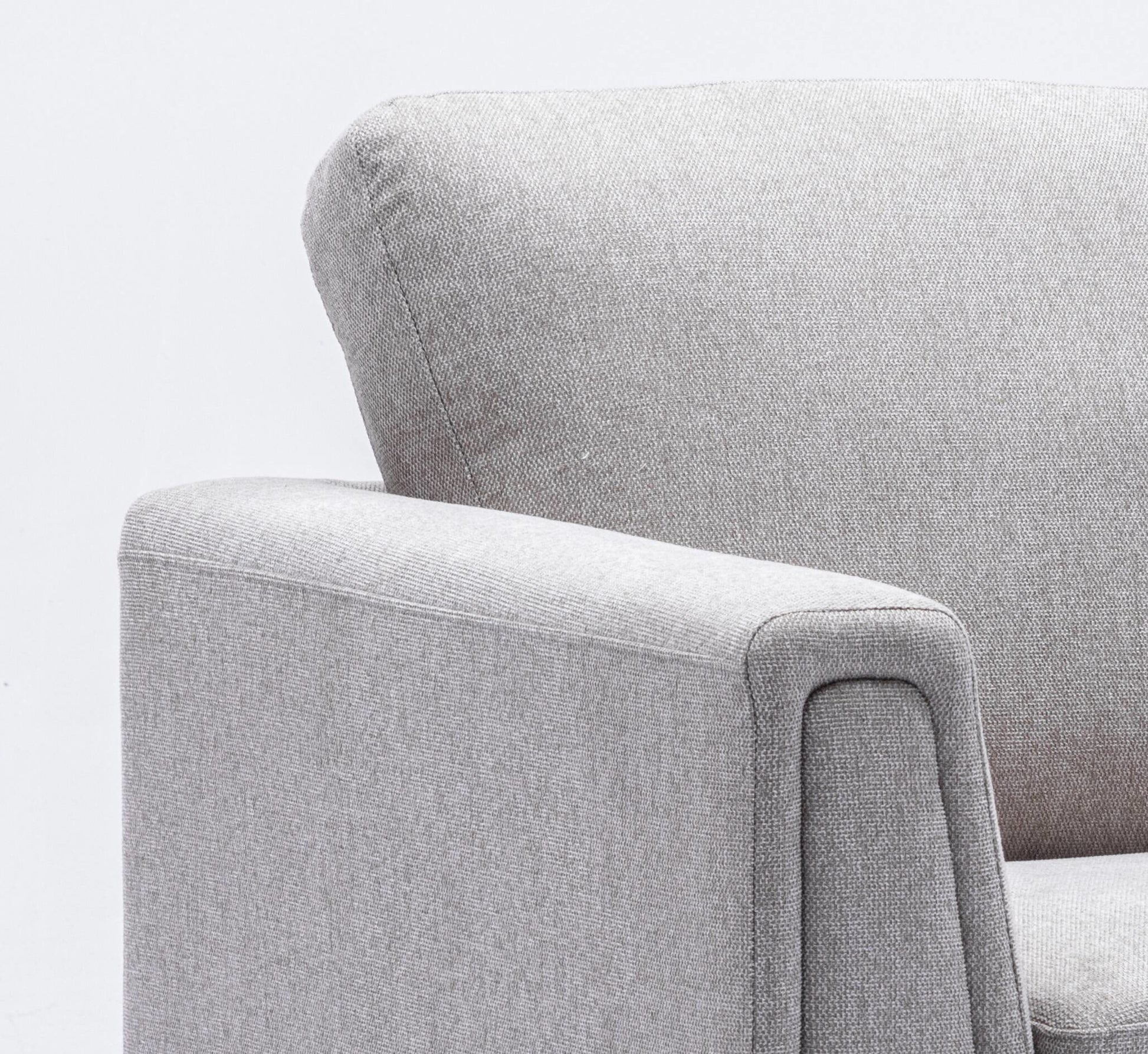 Closeup of a textured light grey fabric armchair armrest and back cushion