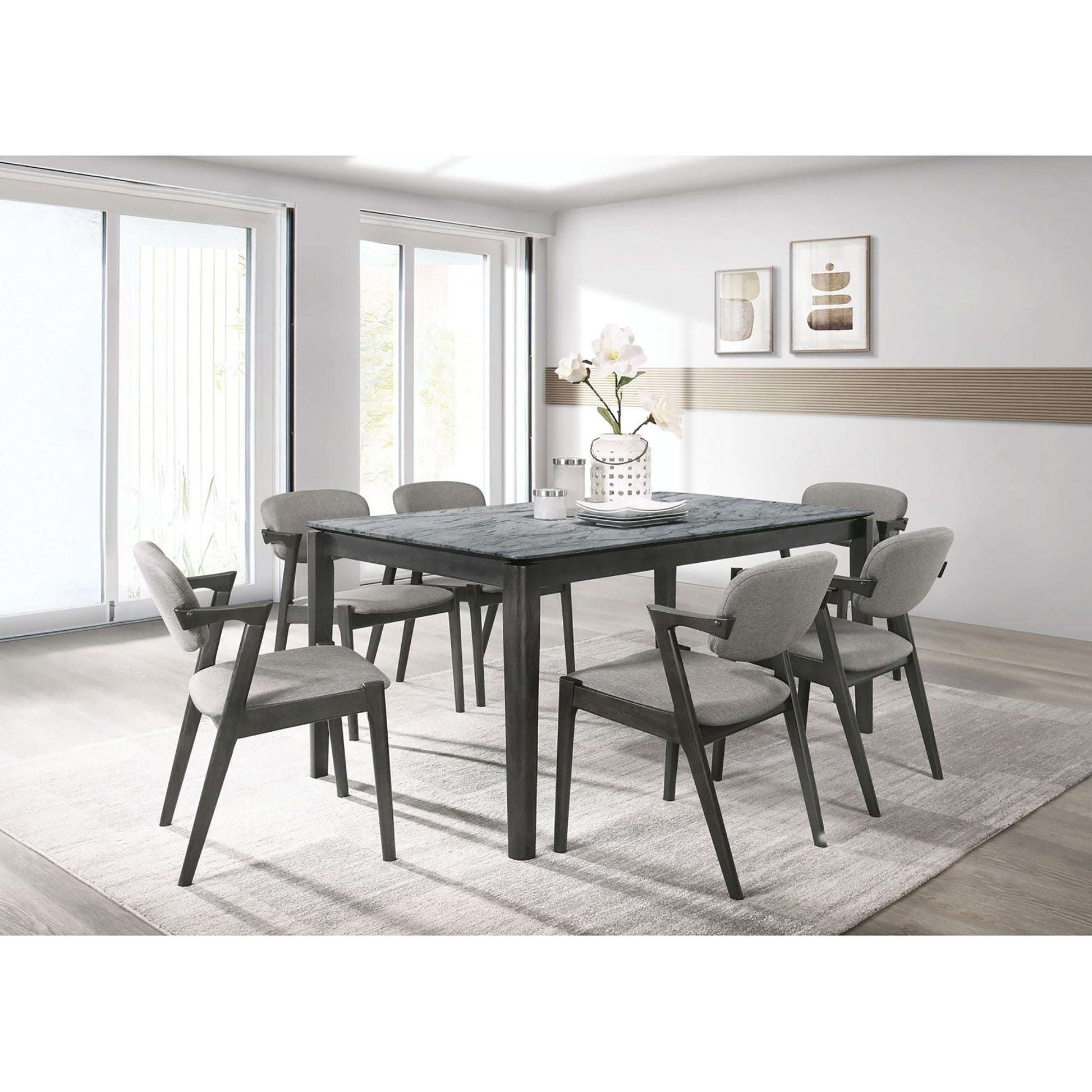 Gray upholstered dining chairs with dark wood frames surrounding a marbletop dining table