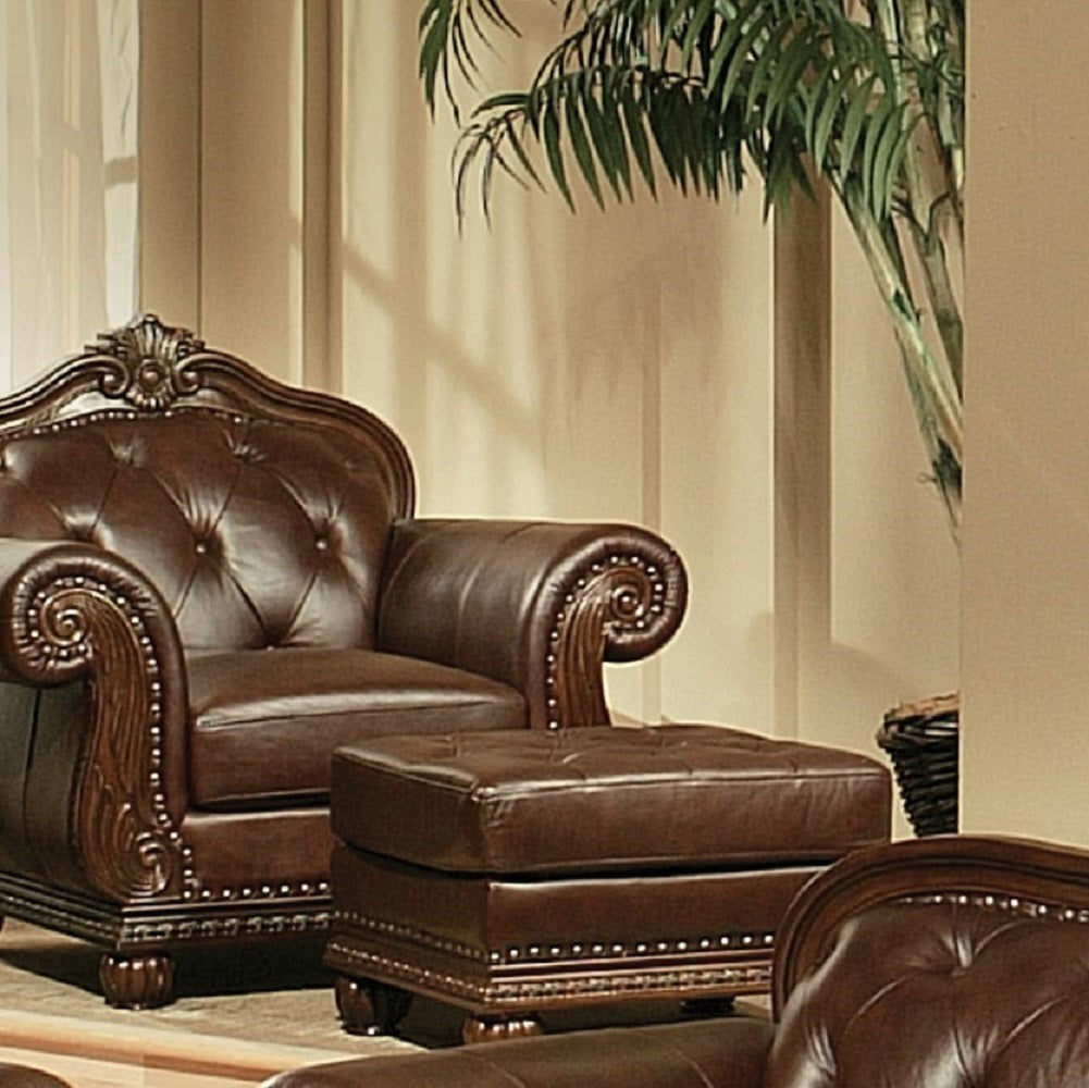 Tufted dark brown leather accent chair with ornate wooden trim and brass nailhead accents