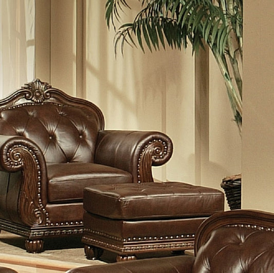 Tufted dark brown leather accent chair with ornate wooden trim and brass nailhead accents