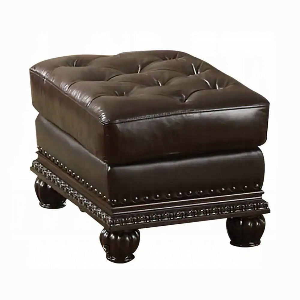 Tufted dark brown faux leather ottoman with decorative nailhead trim and carved wooden legs