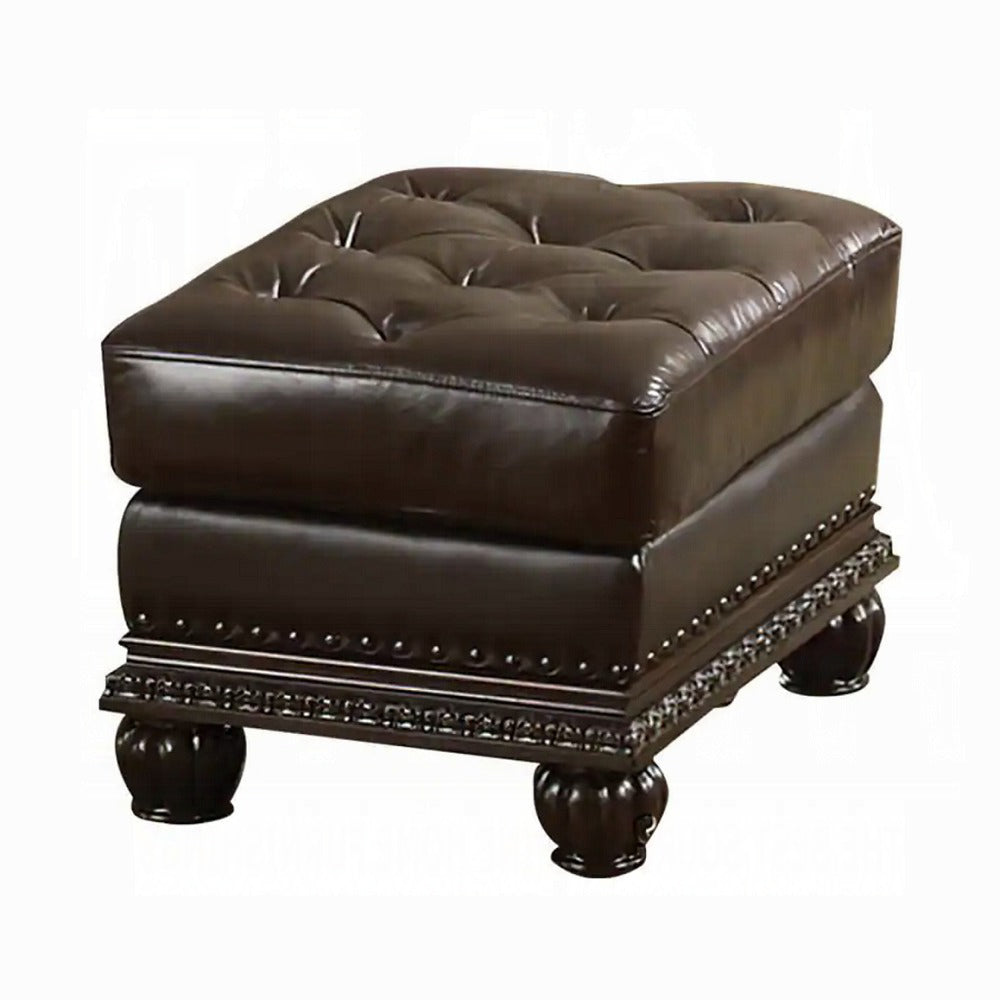 Dark brown tufted leather ottoman with ornate carved legs and brass nailhead trim