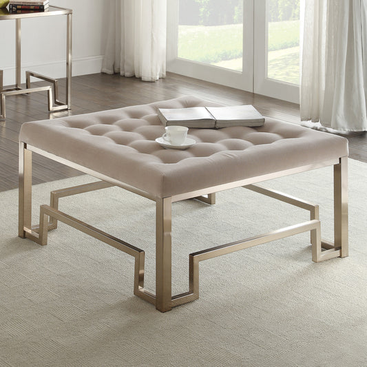Tufted beige upholstered ottoman with a modern geometric brushed nickel base