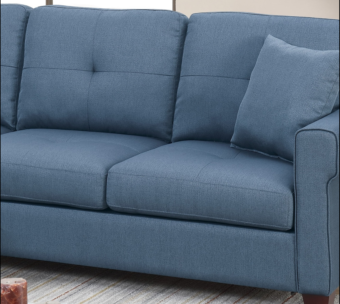 Blue fabric sofa with tufted back cushions and a matching throw pillow