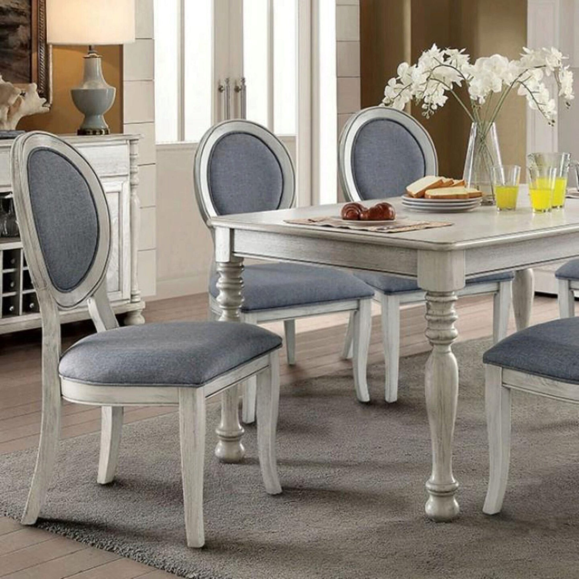 Elegant distressed white dining chairs with blue upholstered seats and oval backs