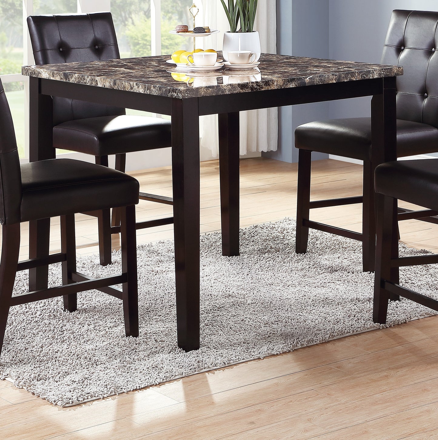Square faux marble top dining table with dark wood frame and four tufted chairs