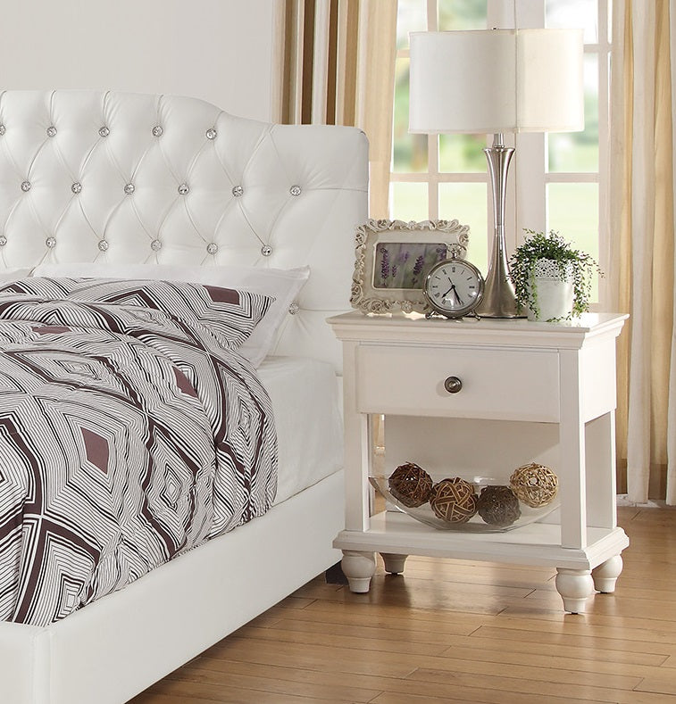 White tufted upholstered headboard bed with crystal accents and geometric patterned bedding