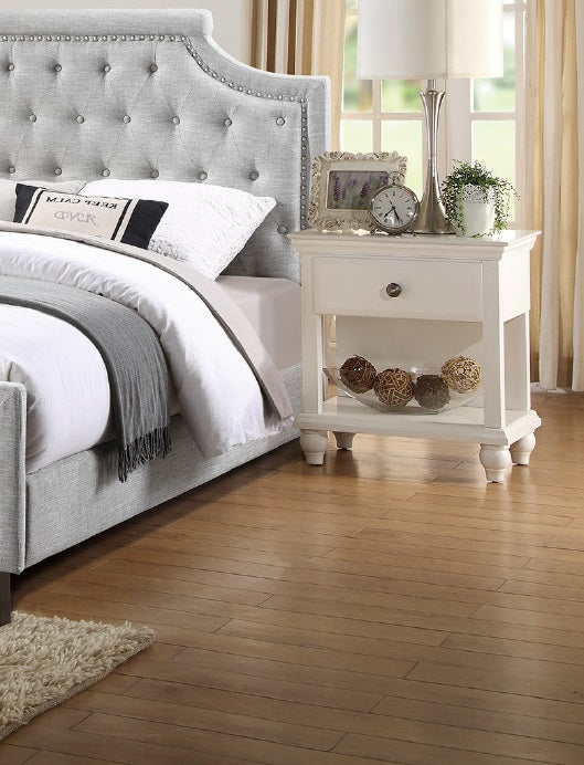 Tufted grey fabric headboard with silver nailhead trim and button tufting