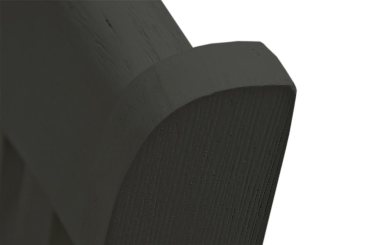 Closeup of a dark gray wooden carved accent piece with linear texture