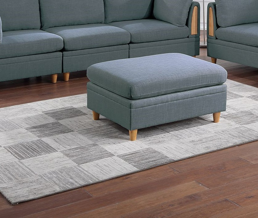 Blue linen upholstered storage ottoman with wooden legs on checkered rug