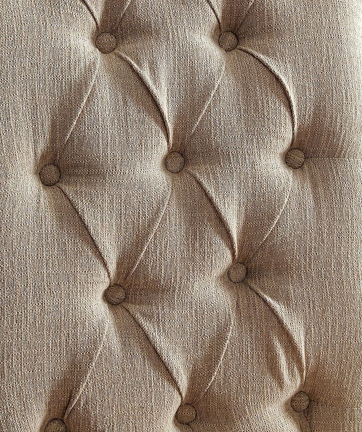 Close up of beige textured fabric with diamond tufting detail