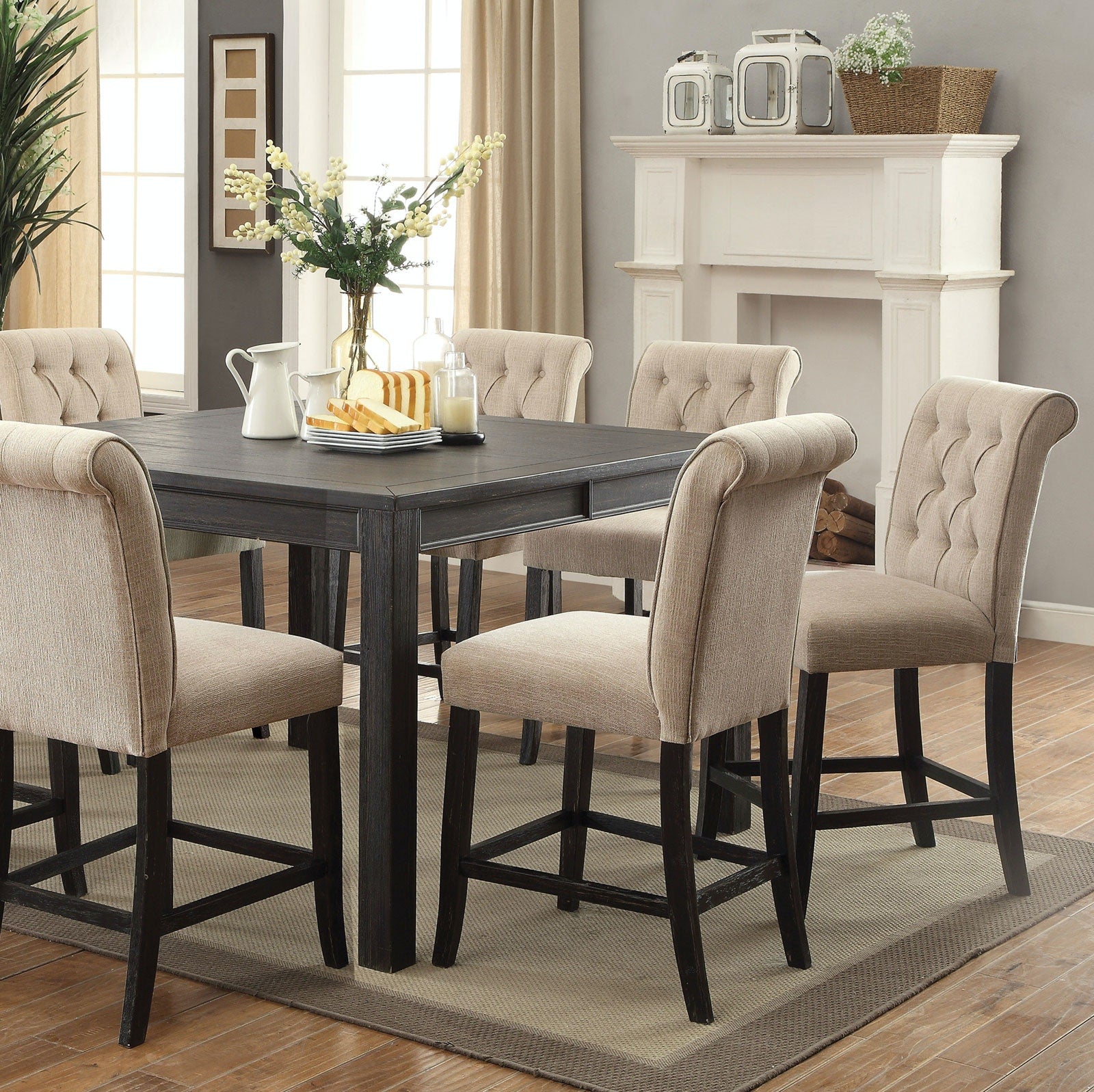 Tufted beige fabric counter stools with dark wood legs around a dark wood counter table