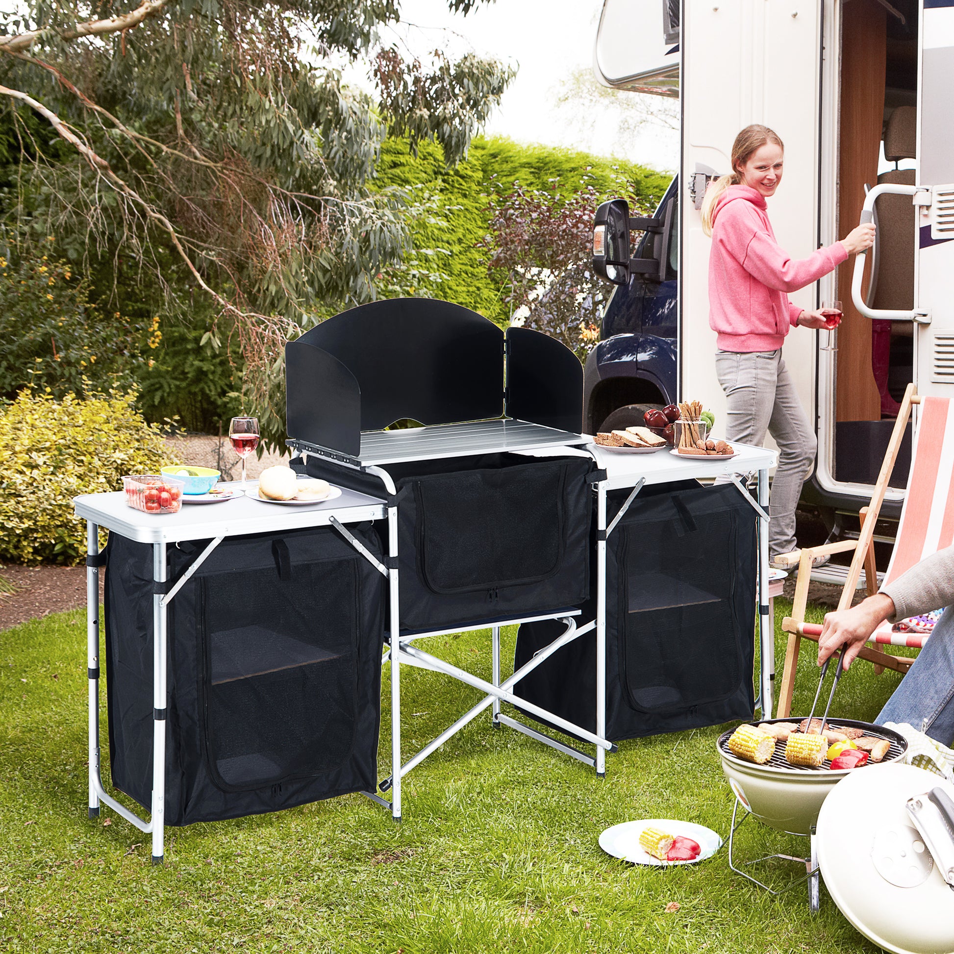 Portable camping kitchen table with black storage bags and wind guard ideal for outdoor cooking
